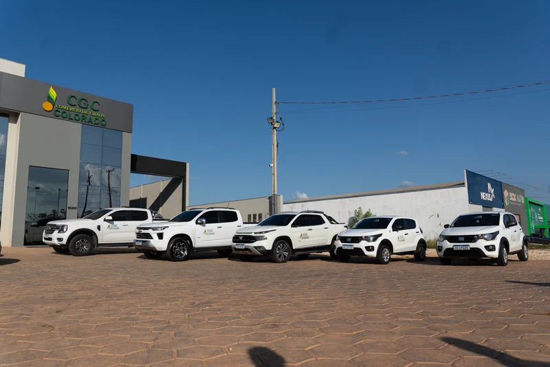 Carros e caminhonetes brancas com o logo da CGC estacionados na frente da sede